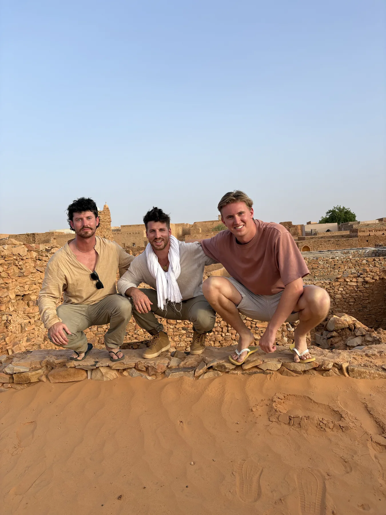 Three travelers at the ancient stone ruins of Chinguetti, Mauritania
